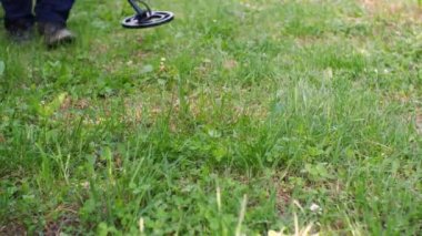 Ödül aramak için metal dedektörüyle kameraya doğru ilerleyen bir adam.