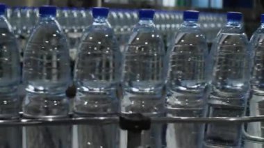 Maden suyu şişeleri taşıyıcı boyunca sürekli bir akarsu içinde hareket eder. Yiyecek işleme tesisinde içme suyu üretimi