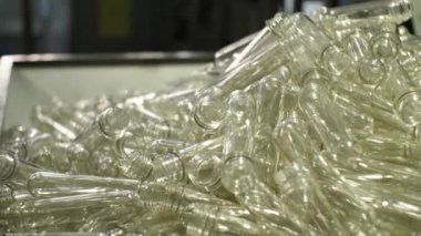 Plastik şişe üflemek için beyaz önlüklü bir hopper. İçme ve maden suyu üretimi için bitki.