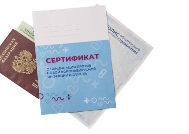 Belgeler ve aşı sertifikası beyaz arka planda izole edilmiştir. Rusça yazı: yeni bir koronavirüs enfeksiyonuna karşı aşı sertifikası COVID-19 