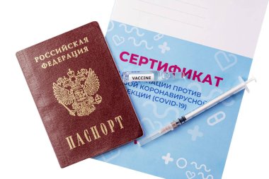 Şırınganın yakın çekimi, aşılı ampuller ve aşı sertifikasında yatan pasaport. Rusça yazı: yeni bir koronavirüs enfeksiyonuna karşı aşı sertifikası COVID-19
