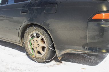 Kış yolundaki bir arabanın lastiklerinde kar zincirleri. Karlı bir otoyolda güvenlik kavramı