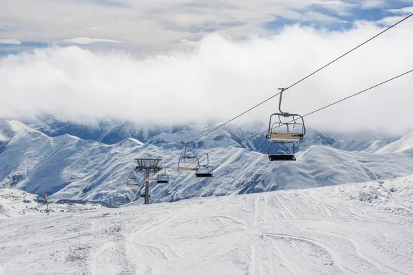 Karla kaplı sırtların arka planındaki boş bir teleferik sıkılaştırılmış. Aktif kış tatili kavramı