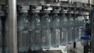 Dolum ünitesinde 1,5 litre su bulunan plastik bir şişeye otomatik olarak doldurma işlemi. Yiyecek işleme tesisinde içme suyu üretimi