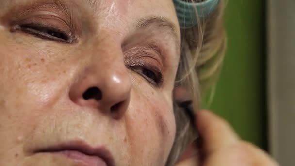 自宅で化粧をしている年配の女性のクローズアップ 影で目を上げる — ストック動画