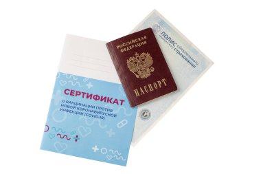 Pasaportun üst görüntüsü, sigorta poliçesi ve aşı sertifikası. Çeviri: yeni bir koronavirüs enfeksiyonuna karşı aşı sertifikası COVID-19