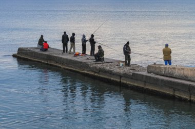 Sudak, Kırım Cumhuriyeti, 5 Kasım 2011: Denizdeki beton iskelede balıkçı grupları