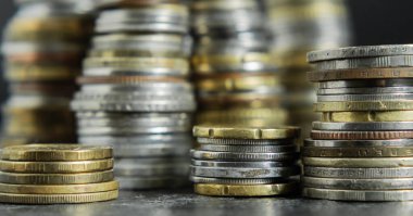Çerçeve boyunca yığınla farklı madeni para. Seçici odaklanma. Finans ve tasarruf kavramı. Yakın plan.