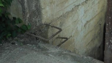 Eski beton bir duvara yakın plan ve destek parantez şeklinde. Bir merdiven rolünü oynar. Terk edilmiş bir hidrolik yapının elementi