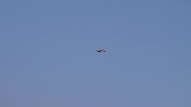 Yanıp sönen fenerleri olan ve iniş takımları açık olan uçak akşam mavisi gökyüzünün arka planına doğru uçuyor. Alt kenar görünümü