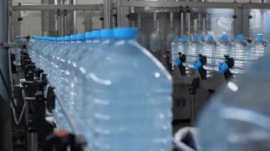 Otomatik içme suyu üretim hattı. Konveyördeki dükkanda 5 litre C vitamini.