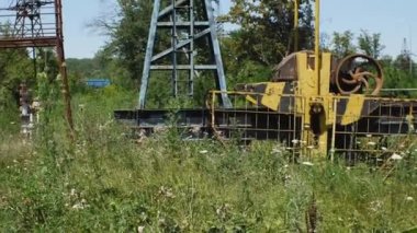 Durmuş ve kısmen parçalanmış bir petrol platformu mavi gökyüzüne karşı. Kamera aşağıdan yukarıya doğru hareket ediyor. Petrol ve gaz endüstrisinin çöküşü kavramı