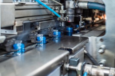 Yeni şişmiş plastik şişeler üfleme makinesinden çıkıyor. Gıda üretimi