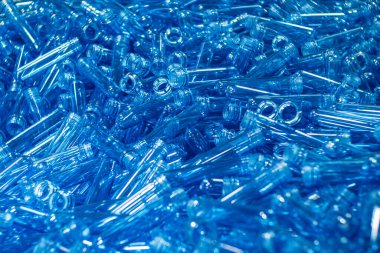 Bir buçuk litrelik mavi plastik preform yığını. Seçici odaklanma. Arkaplan resmi. Gıda üretimi