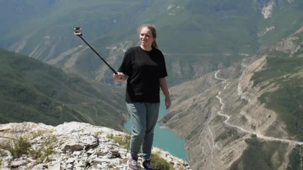 Девушка Черной Футболке Стреляет Себя Камерой Стоящей Краю Красивого Каньона — стоковое видео