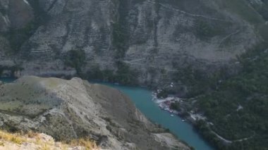 Nehir yeşiliyle birlikte kanyonun kıvrımlarının manzarası. Gün batımı zamanı. Nehirden bir sürat teknesi geçiyor. Seyahat Konsepti