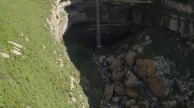 Büyük bir yükseklikten bir su akıntısı taştan bir kaseye düşer. Tobot Şelalesi, Dağıstan Cumhuriyeti, Rusya. Ülkenizde seyahat kavramı
