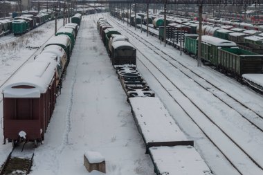 Yük vagonları ve platformlar karla kaplı. Kışın yukarıdan tren istasyonu manzarası. Demiryolu taşımacılığı kavramı. Krasnodar, Rusya, 18 Şubat 2021