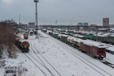 Pistte farklı tipte arabaları olan karla kaplı tren istasyonu. Demiryolu taşımacılığı kavramı. Krasnodar, Rusya, 18 Şubat 2021