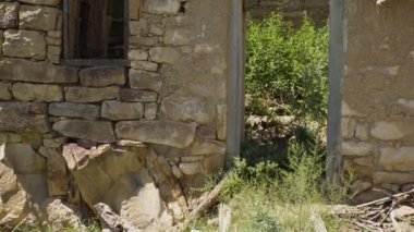 Boş kapısı ve penceresi olan terk edilmiş bir taş bina. Hayalet kasaba. Medeniyetin sonu kavramı.