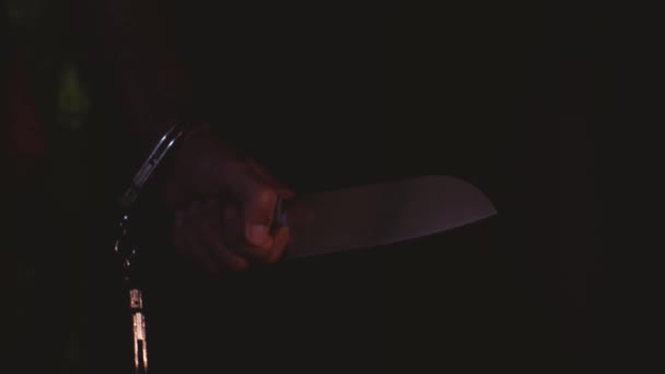 一个戴手铐和刀的男人的手这把刀的刀片与光一起弹奏 然后击中 杀人狂的概念 — 图库视频影像