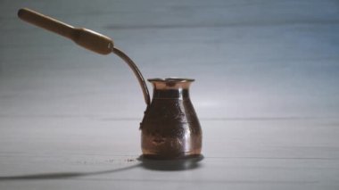 Copper Cezve 'in hafif arka planda kalıpları var. Tahta bir kaşık öğütülmüş kahveyi içine döker. Türk Kahve Yapım Süreci.