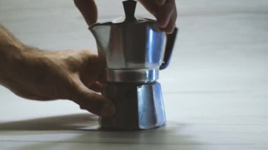 İnsanlar Geyser kahve makinesinde kahve yapmak için ellerini gevşetiyor. Hafif arkaplan. Evde lezzetli kahve yapma süreci..