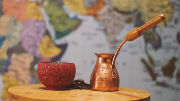 在厨房内部的背景中 有一个铜锅 一个红杯和一把咖啡豆 摄像机在周围飞来飞去 视差效应 土耳其咖啡的概念 — 图库视频影像