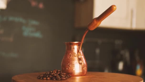キッチンのインテリアの背景にローストコーヒー豆と小さな銅のセブの一握り カメラが飛び回っている パララックス効果 トルココーヒー作りの概念 — ストック動画