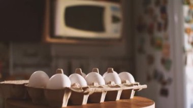 Mutfağın arka planına karşı on tane beyaz yumurta paketi. Kamera etrafta uçuyor. Parallaks etkisi. Doğal ve sağlıklı gıda kavramı