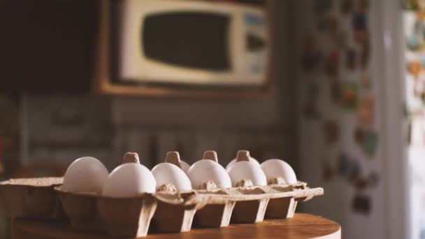 キッチンのインテリアを背景に10個の白い卵のパッケージ カメラが飛び回っている パララックス効果 自然食品と健康食品の概念 — ストック動画
