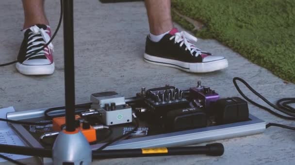 Voeten Van Gitarist Sneakers Tegen Een Achtergrond Van Gitaarprocessors Primers — Stockvideo