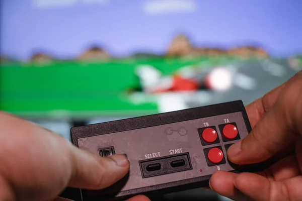 Görüntünün arka planında eski joystick 'le el oyunu oynanıyor. Ev eğlencesi konsepti