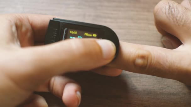 Man Puts Oxiometer His Finger While Measurement Values Displayed Lcd — Stock Video