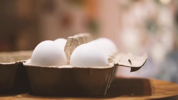 キッチンのインテリアを背景に数十個の白い卵と段ボールパッケージ カメラが飛び回っている パララックス効果 自然食品と健康食品の概念 — ストック動画
