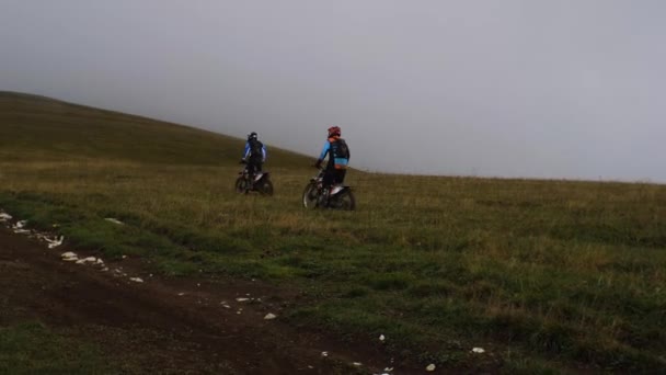 山の未舗装の道路に乗ってクロスカントリーバイクで2台のオートバイ それらの前には Atvとハイカー歩くことです 2021年9月19日ロシア アディジェ共和国 — ストック動画