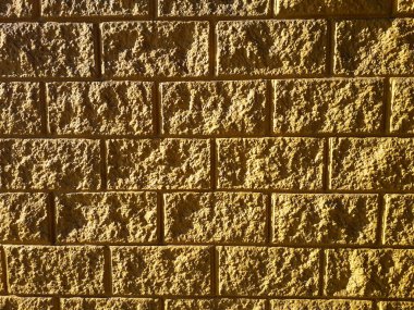 Duvar, desenli, özet, özgeçmiş. Dokulu sarı bir duvarın fotoğrafı. Doğal ışık. Brezilya 'da sert duvar olarak bilinir..