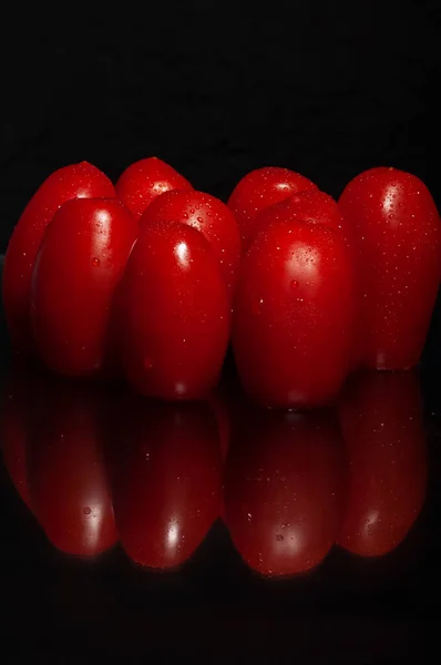 Close Tomates Cereja Molhados Gotas Água Vermelho Brilhante Fundo Preto — Fotografia de Stock
