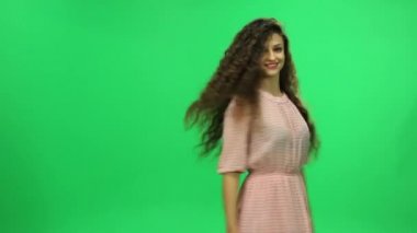 Etrafında dönen ve gülümseyen güzel kız. Yeşil ekran.