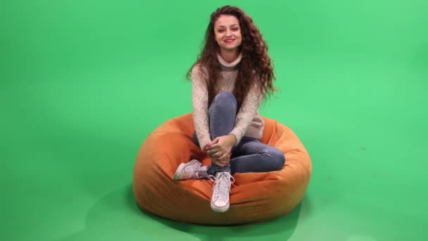 Girl sitting on bean bag, relax ans smile — Stock Video