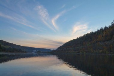 Sonbaharda gün batımından sonra nehir dağlar ve ormanın arka planına karşı. 