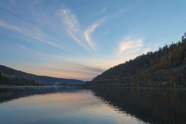 Sonbaharda gün batımından sonra nehir dağlar ve ormanın arka planına karşı. 