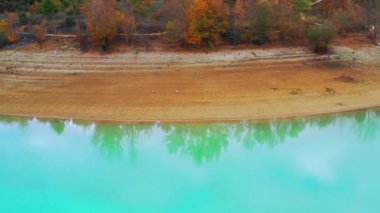 Alloz rezervuar kıyısı ve sonbahar ormanı. Hava görüntüsü. Navarre, İspanya, Avrupa. 4K.