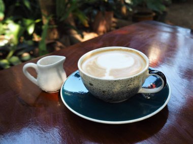 Ahşap masada bir fincan kahve.