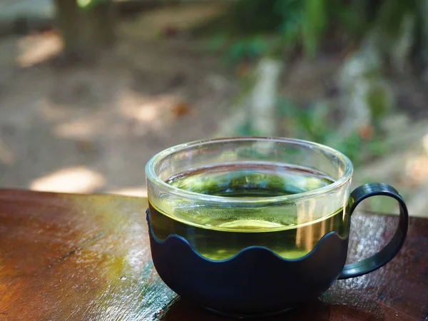 木のテーブルの上の瓶とガラスの中の緑茶 — ストック写真