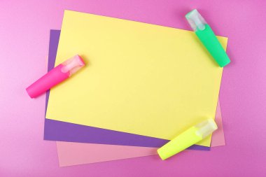 Pembe arka planda işaretleri olan renkli kağıtlar..