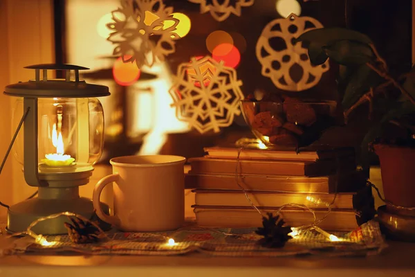 マグカップ付きコーヒー本キャンドルスティック付きクリスマスキャンドルや窓のガーランド — ストック写真