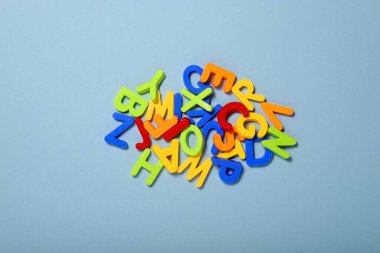 Mavi arkaplanda Latin alfabesinin çok renkli plastik harfleri