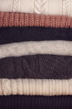 Çok renkli yün katlanmış kazak yığını.