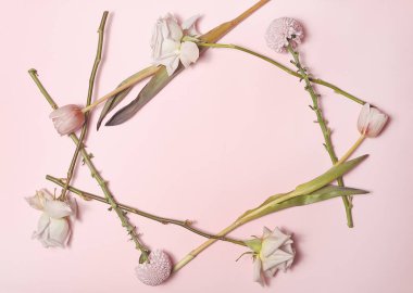 Çiçek çerçevesi lale karanfilleri ve pembe arka planda güller.